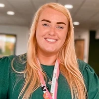 Blond female smiling wearing green dress