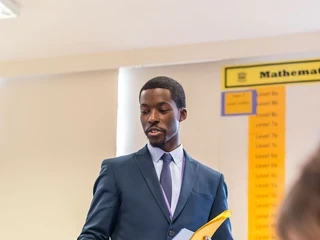 Teacher handing out worksheets to students